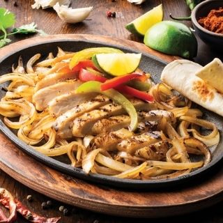 Classic Chicken Fajitas: Chicken grilled over mesquite wood served sizzling alongside hand-pressed flour tortillas, pico de gallo, cheese, Mexican rice and choice of beans.