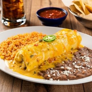 Classic Burrito: Seasoned ground beef or chicken tinga, pico de gallo and cheese rolled in a flour tortilla smothered with chile con carne, sour cream sauce, salsa verde, roasted red chile tomatillo salsa or our signature queso. Served with Mexican rice and choice of beans.