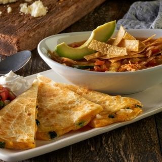 Quesadilla Combo: A lunch-size chicken, steak, brisket or veggie quesadilla served with pico de gallo, sour cream and guacamole, plus a cup of chicken tortilla soup or house salad.