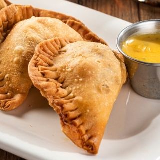 Empanadas: Two handmade pastries filled with mixed cheese & seasoned ground beef. Served with our signature queso.