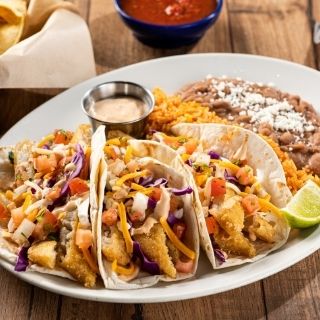 Dos XX® Fish Tacos: Dos XX beer-battered fish, creamy red chile sauce, shredded cabbage, mixed cheese and pico de gallo.