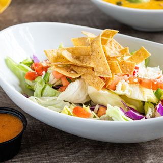 Large House Salad: A crisp blend of lettuce & shredded cabbage and pico de gallo. Topped with tortilla strips and queso fresco. Served with choice of dressing.