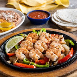 Grilled Shrimp Fajitas: Shrimp grilled over mesquite wood served sizzling alongside hand-pressed flour tortillas, pico de gallo, cheese, Mexican rice and choice of beans.
