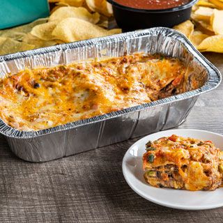 Veggie Mexican Casserole: Layers of white corn tortillas, roasted red chile tomatillo salsa, sautéed vegetables, black beans, poblano & onion, queso and melted mixed cheese. Served with our famous chips & salsa and choice of rice & beans or a house salad.