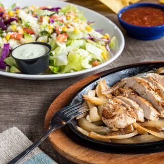 Fajita Salad: Sizzling mesquite-grilled chicken or steak and onions served alongside a crisp blend of lettuce & shredded cabbage, pico de gallo, roasted corn, fresh avocado and queso freso.