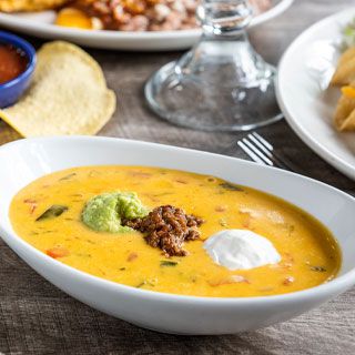 Primo Queso at OTB: Our Guest-favorite Signature Queso topped with seasoned ground beef, guacamole, and sour cream and served with our homemade tortilla chips.