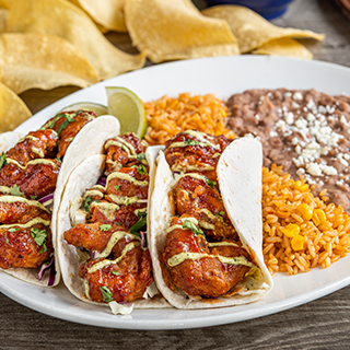 Honey Chipotle Shrimp Tacos: Crispy-fried shrimp tossed in honey-chipotle sauce with cilantro, spicy avocado ranch and shredded cabbage in hand-pressed flour tortillas. Served with Mexican rice and choice of beans.