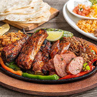 Smokehouse Fajitas: Texas-sized fajita platter with chipotle ribs, jalapeño sausage, braised carnitas, shredded beef brisket and a grilled jalapeño. Served with honey chipotle and jalapeño-BBQ sauces, hand-pressed flour tortillas, pico de gallo, cheese, Mexican rice and choice of beans.