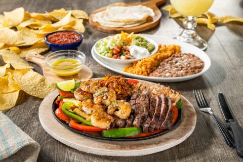 Ultimate Fajita Our famous fajita is back! Mesquite-grilled steak, chicken, shrimp, and braised pork carnitas with sautéed vegetables. Served with warm, hand-pressed flour tortillas, pico de gallo, cheese, Mexican rice, and choice of beans.
